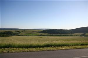 záber na biotop od cesty, monitorovaná lúka je pod lesom a vľavo od lesa